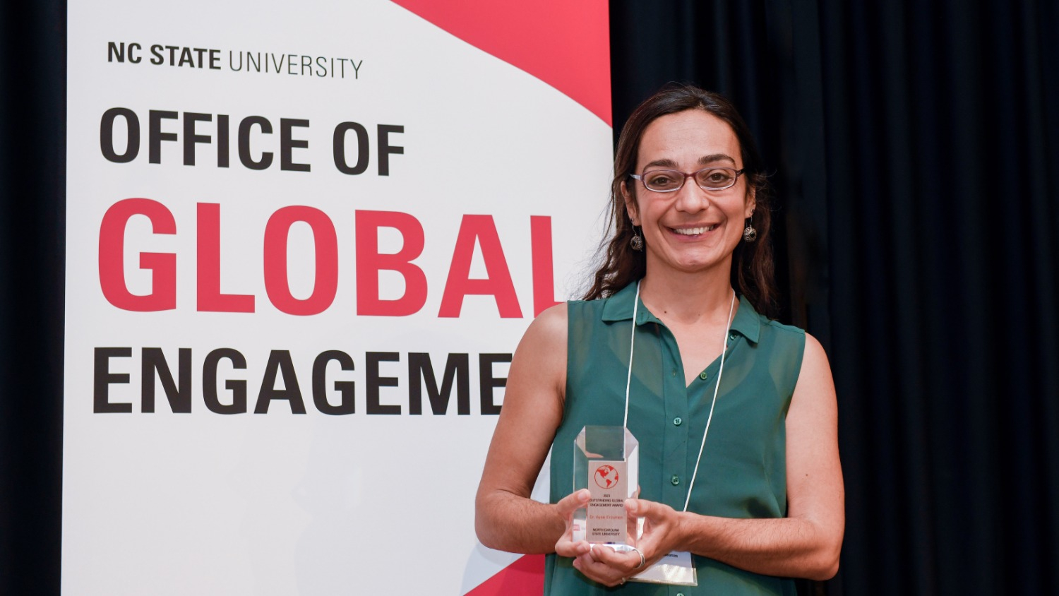 2019 Oustanding Global Engagement Award recipient posing for a picture with their award.