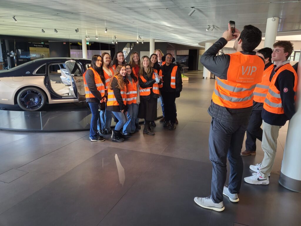 Global Leadership Minor students pose for group picture with a car.