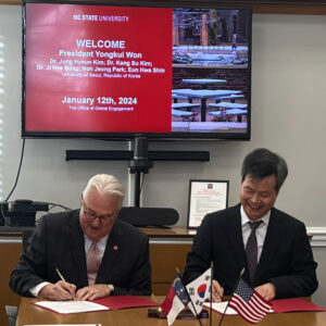 Chancellor Randy Woodson (left) and President of UoS, Yongkul Won (right), signing agreements at the signing ceremony.