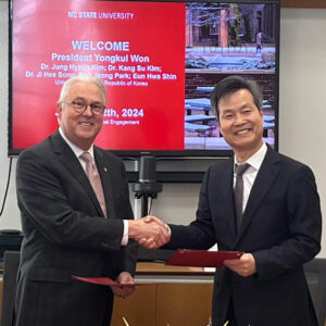 Chancellor Randy Woodson (left) and President of UoS, Yongkul Won (right), shaking hands at the signing ceremony.