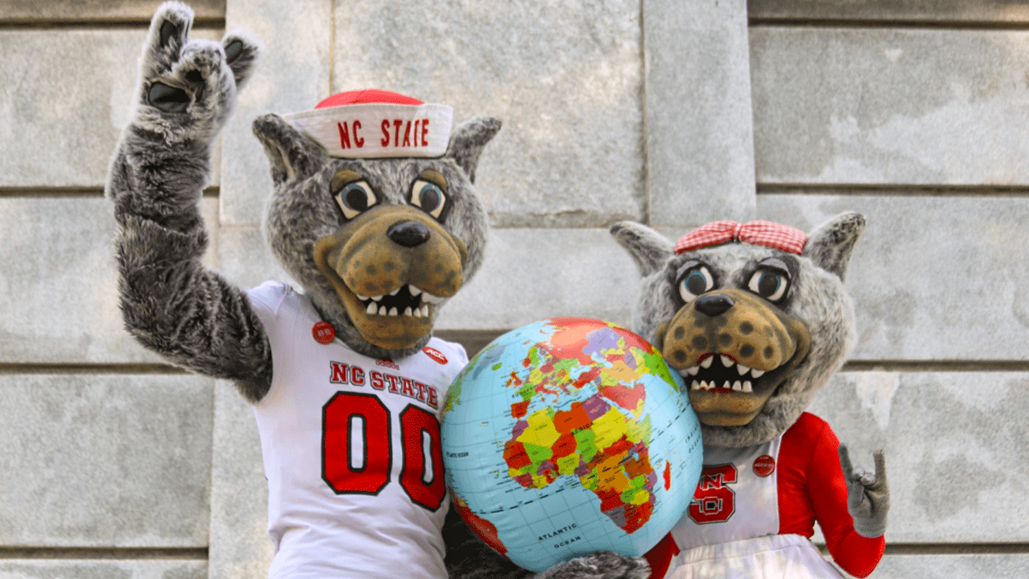 Mr and Mrs Wuf holding a globe