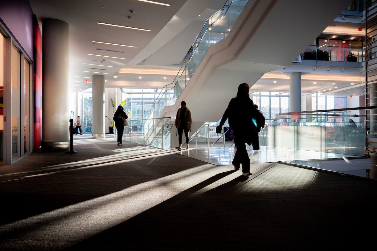 Students walk on the second floor of Talley Student Union, with sunlight coming in through the windows.