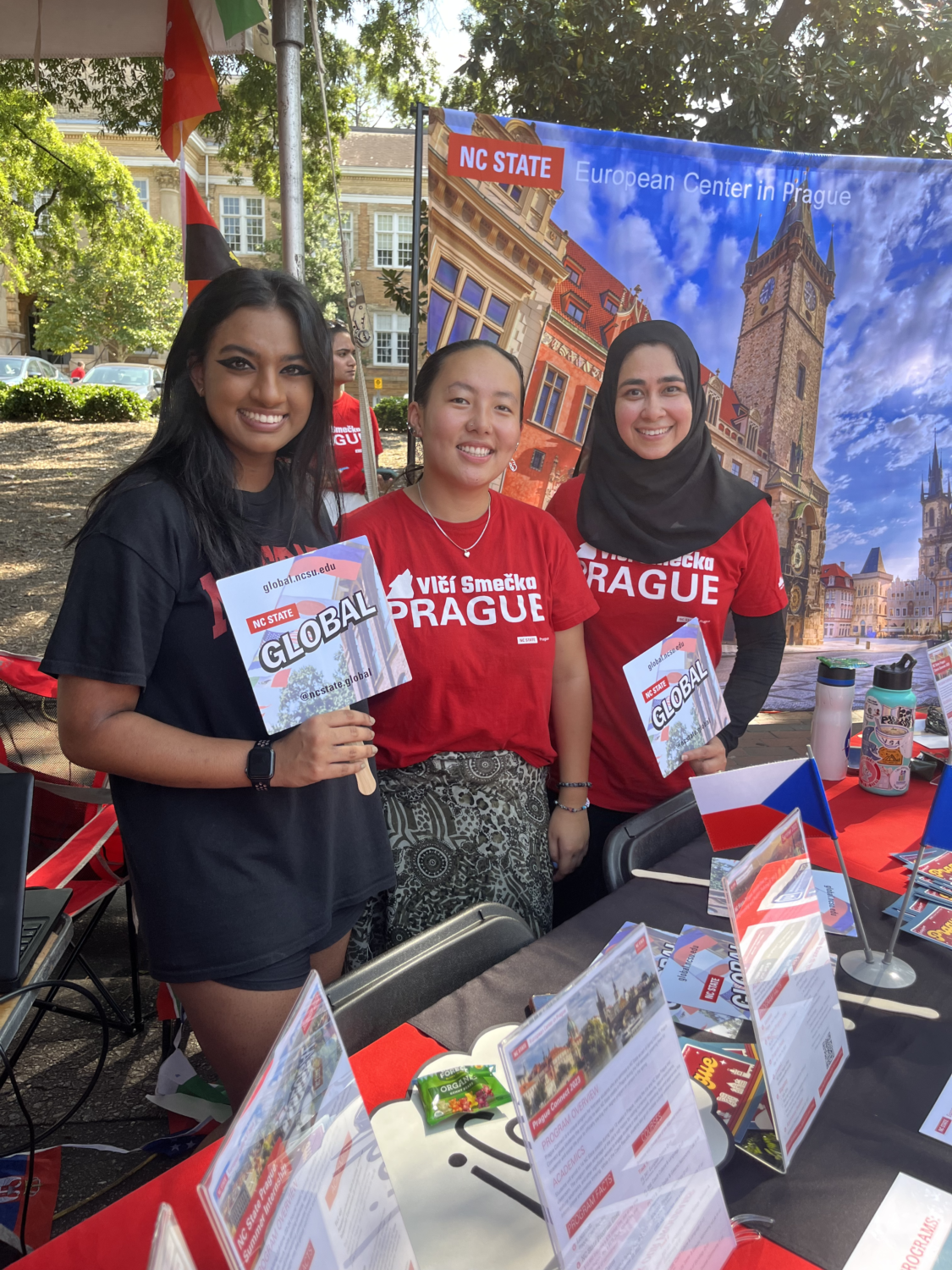 Students holding NC State Global fans at the Packapalooza event