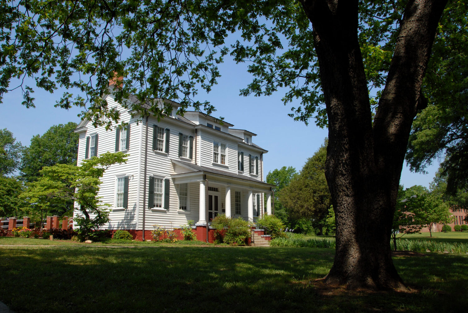 Historic Spring Hill House through the trees on a sunny day