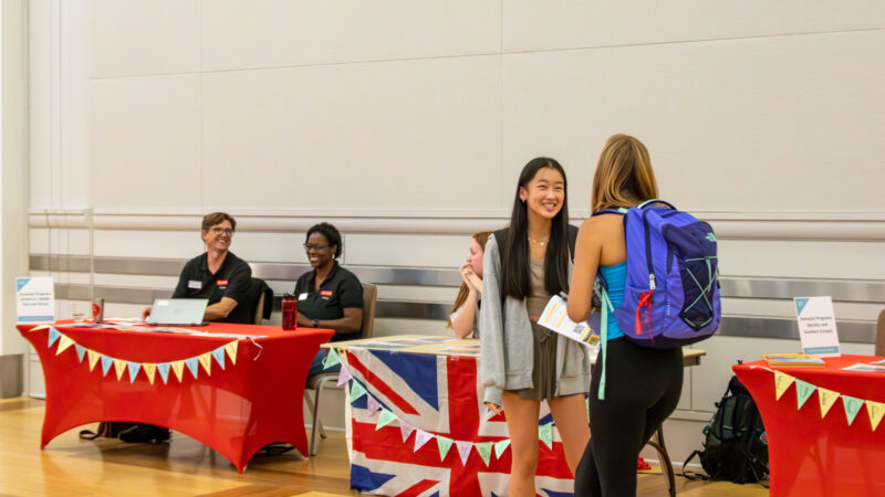 Two students engage in conversation at the Study Abroad Fair. 