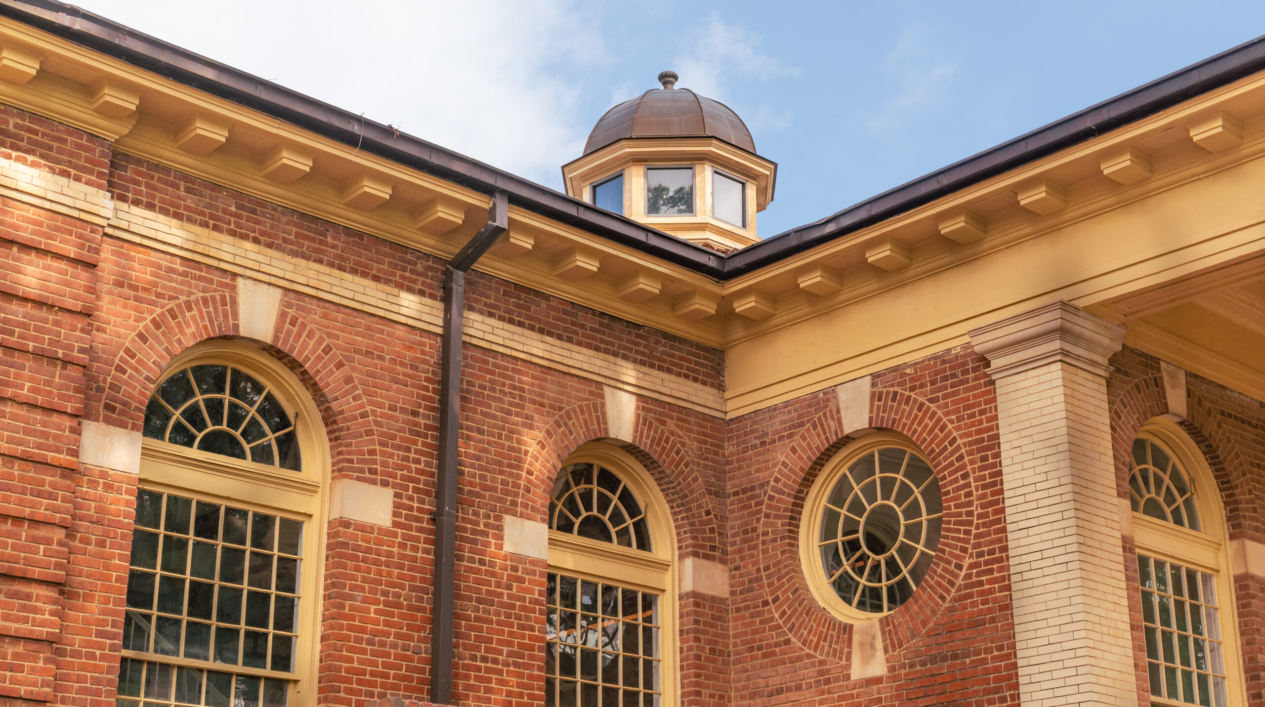 Leazar Hall's architecture of arched windows and brick facade against a blue sky.