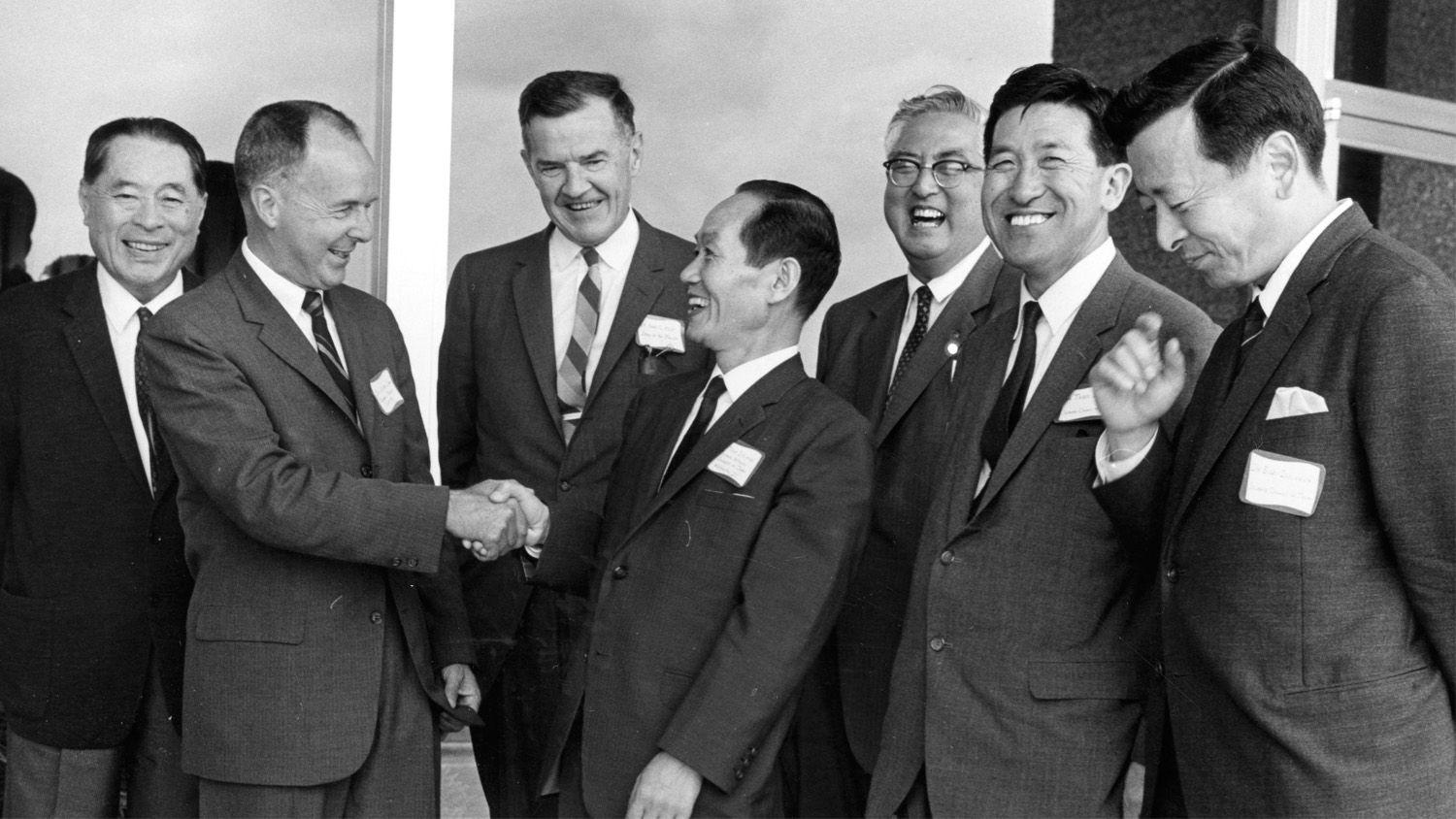 Dean Harry C. Kelly and others greeting Japanese visitors. Photo in black and white. 