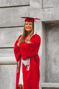 A female student in a red undergraduate gown. 