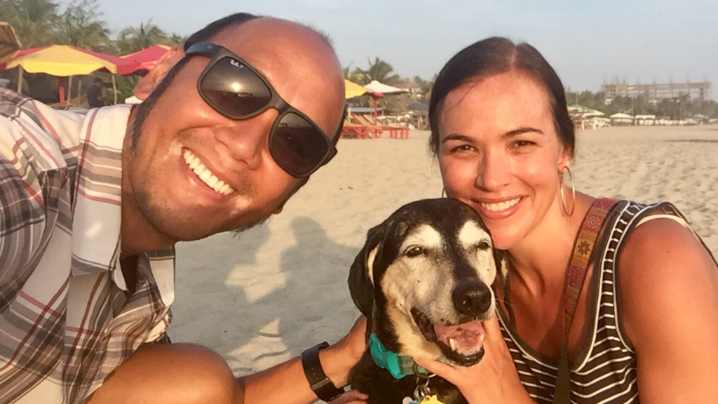 Meg Le and David Le taking a selfie on the beach with their dog.