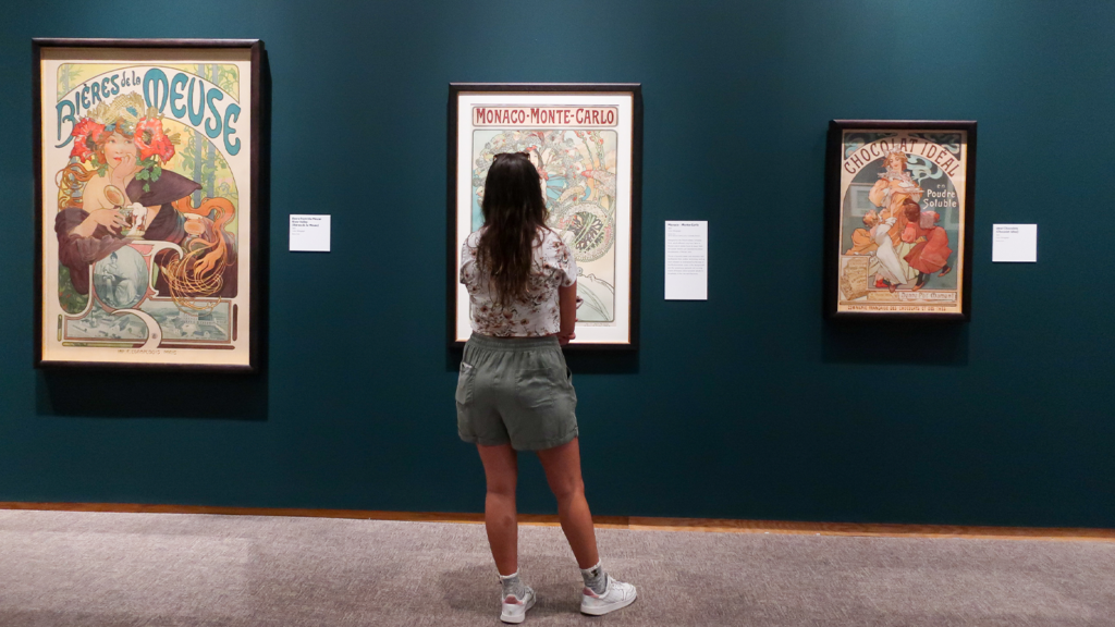 A female student photographed from the back ashe is looking at the MUCHA art exhibition inside of the North Carolina Museum of Art, October 19.