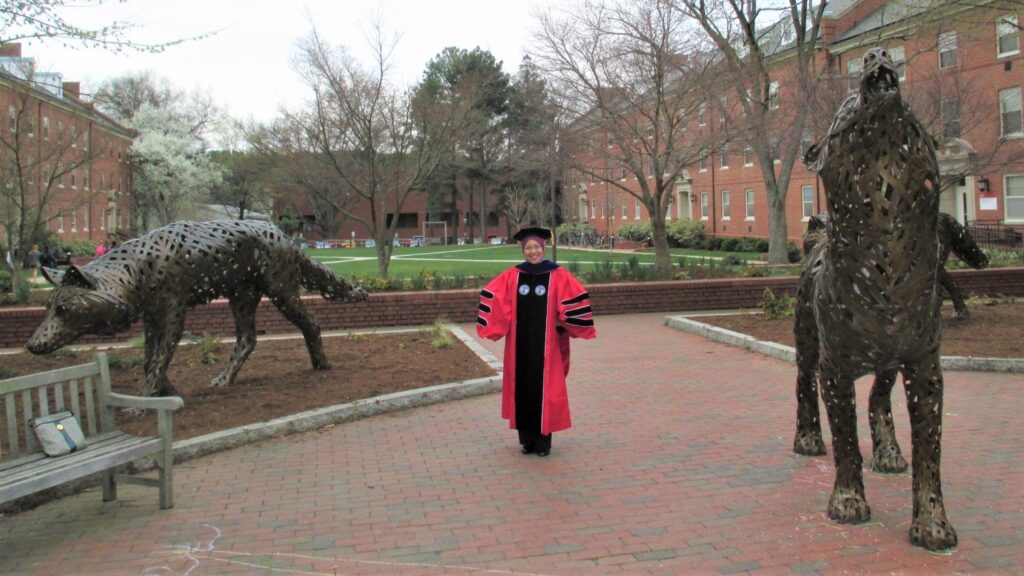 Dr. Judith Gisip in her doctoral gowns at wolf plaza.