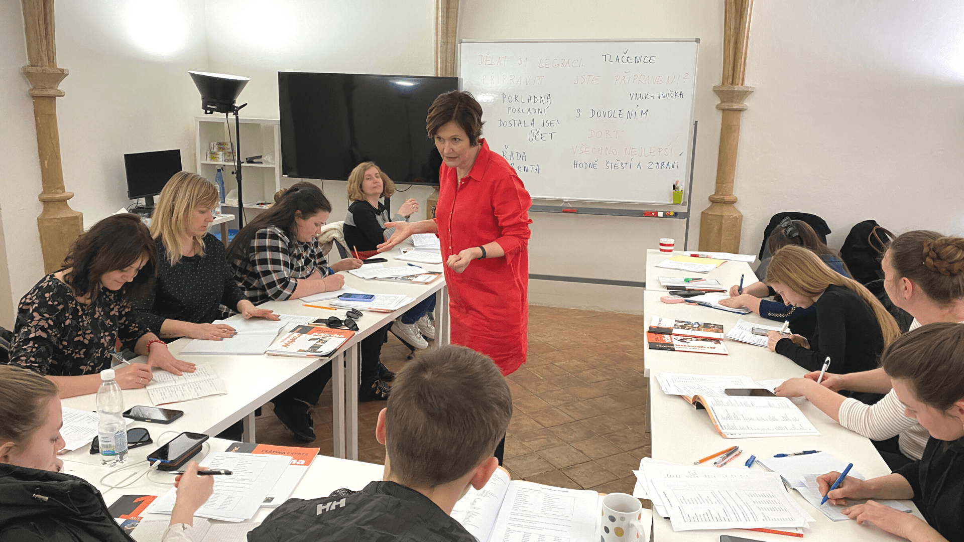 An instructor teaching with students around her taking notes